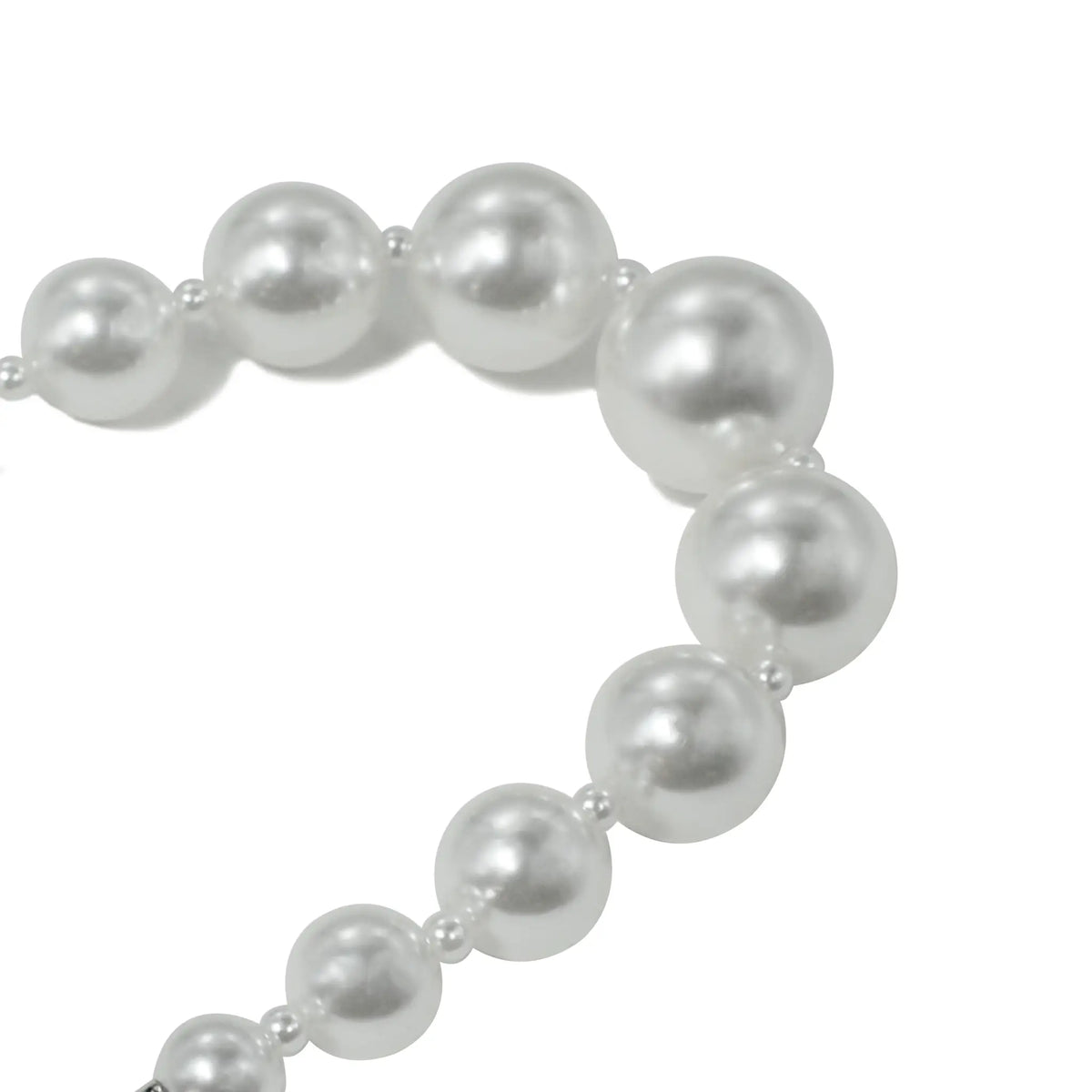 Close-up of small pearl beads on bracelet, highlighting fine details.